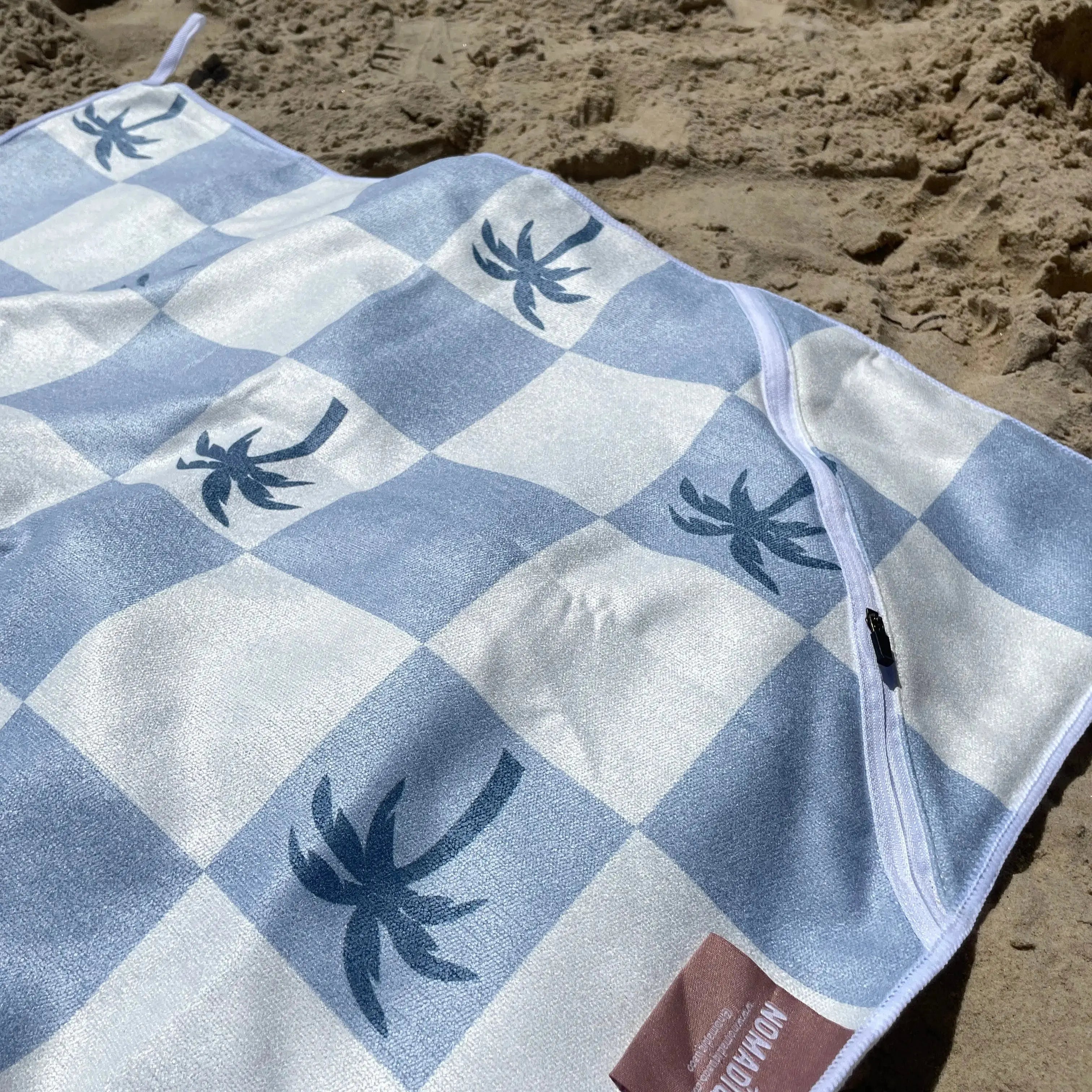 Malibu Blue Checkered sand free Beach Towel With Pocket on white sand beach in Australia