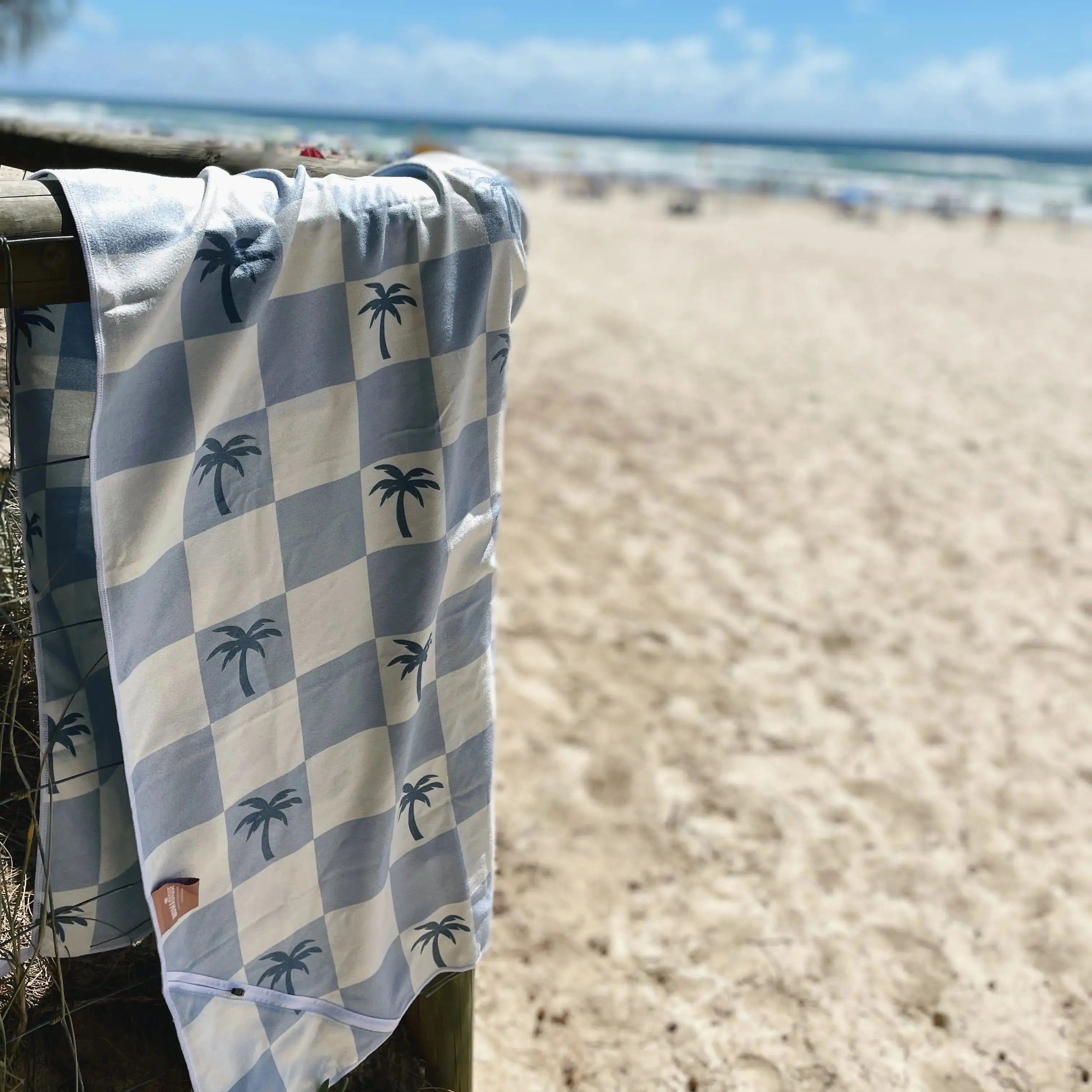 Malibu Blue Checkered sand free Beach Towel With Pocket on white sand beach in Australia