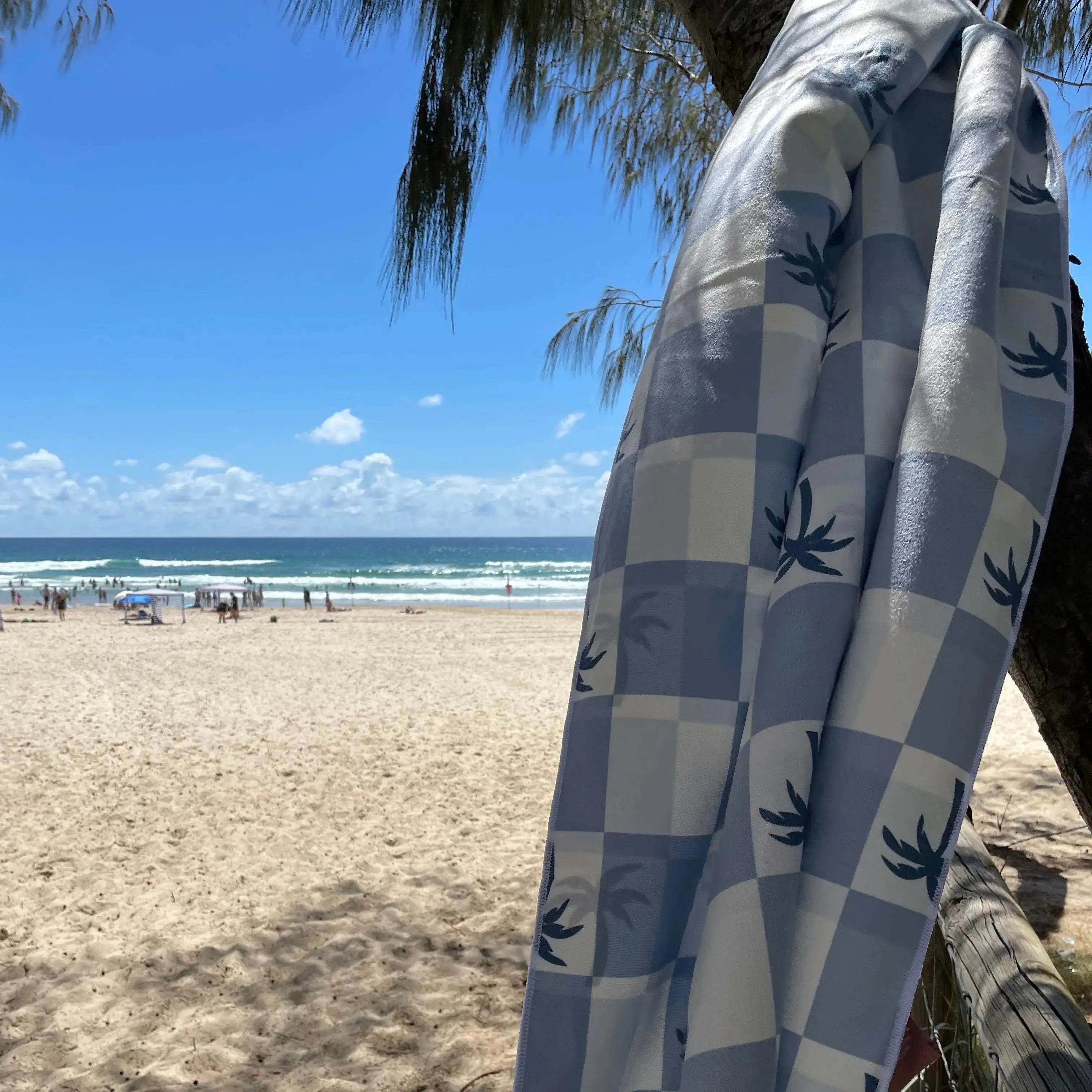 Malibu Blue Checkered sand free Beach Towel With Pocket on white sand beach in Australia