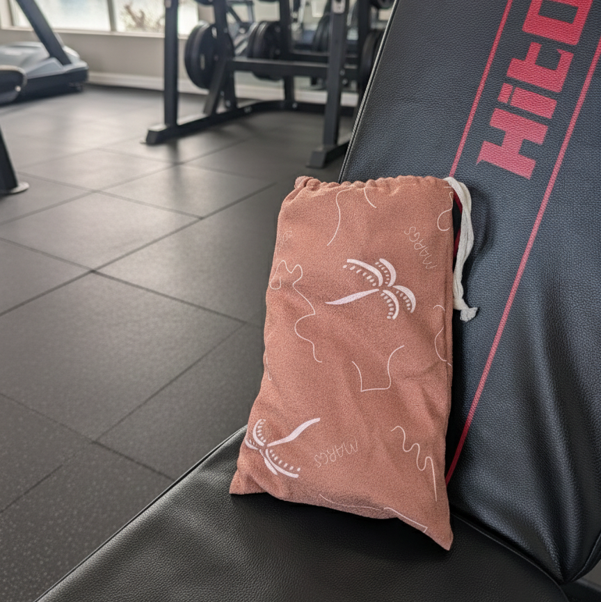 super handy gym towel bag with a functional and refined touch to the design in a spacious, uncluttered gym with patterned flooring and modern fitness machines.