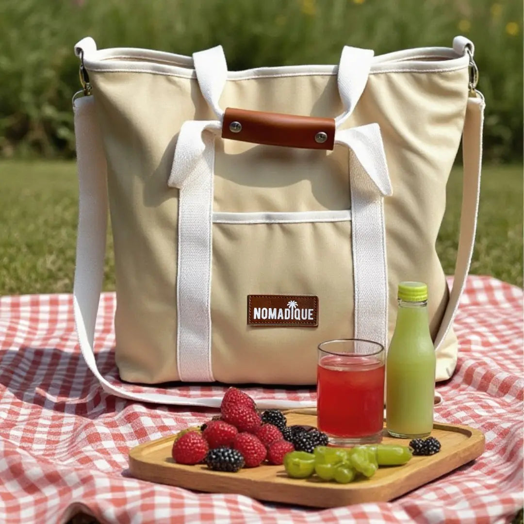 large cooler beach tote bag in beige with a zip pocket, water bottle holder at a picnic keeps food and drinks cool