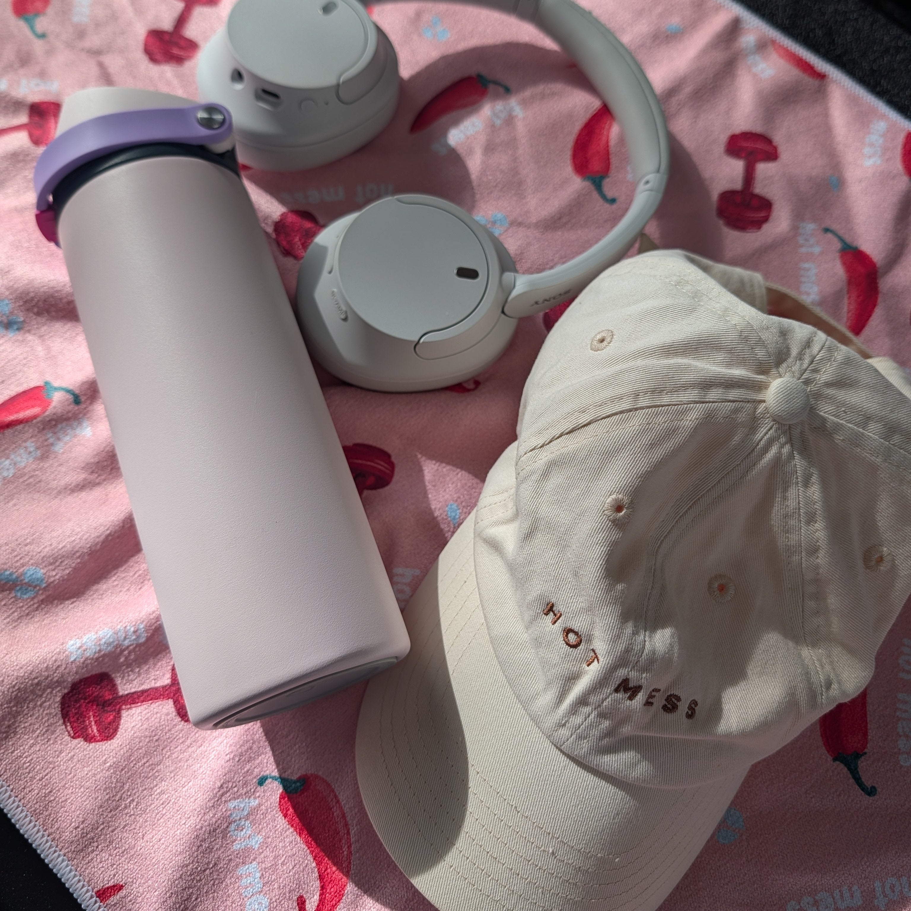 cute pink gym towel design perfectly matched with the HOT MESS baseball cap, gym tumbler, and earphones.