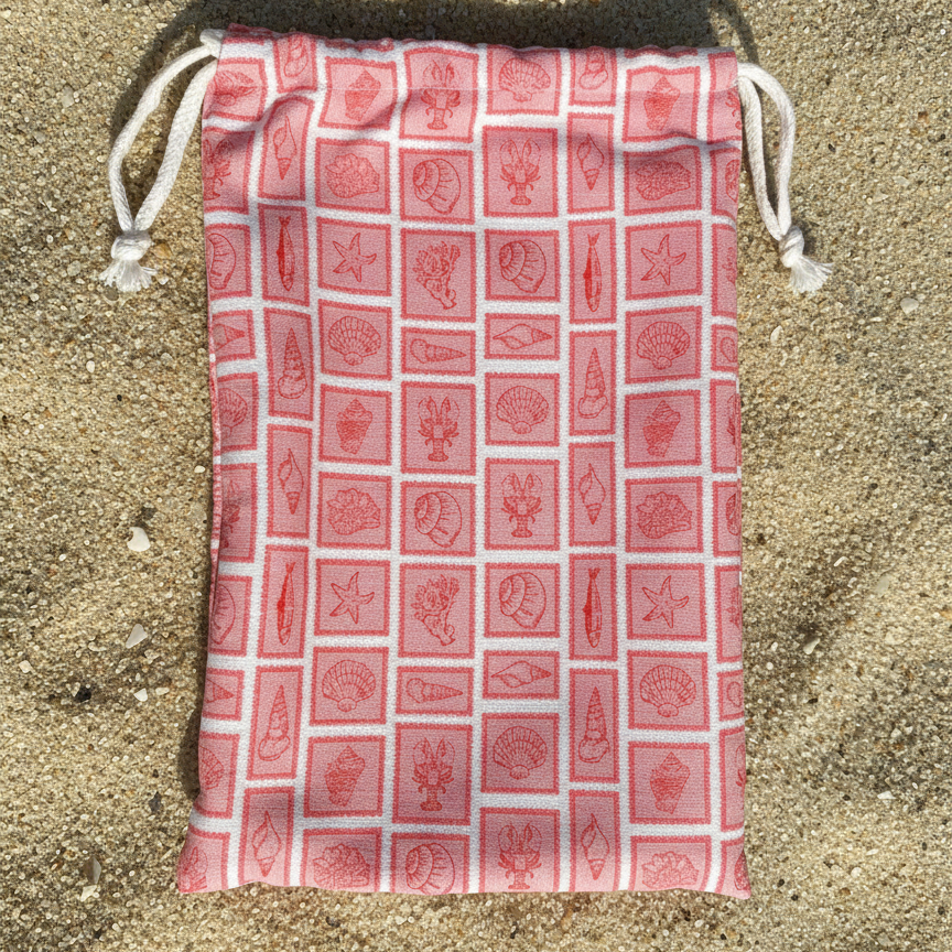 The combination of soft colours and symmetrical geometry gives the towel bag a refined, minimalist look that feels both modern and relaxed, complementing the natural beach environment.